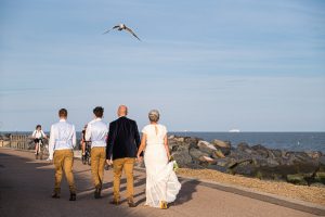 bride and groom walking on the prom at felixstowe