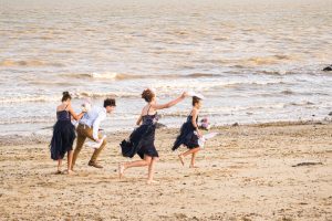 kids at a wedding playing on the beach